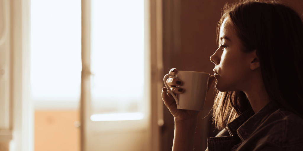 A woman sips a hot drink.